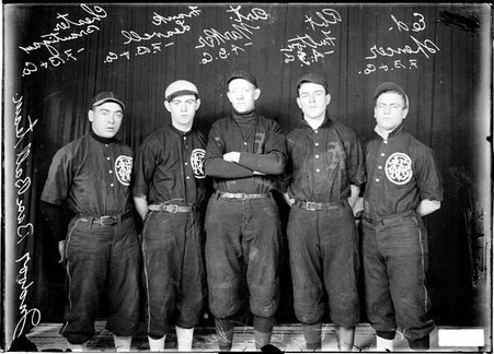 F. B. & Co. indoor baseball players Ed Spencer, Frank Leavell and Chester Brantigan standing with Armour Grain Co. indoor baseball players R. Fulton and A. Marker in front of a dark colored background - Chicago Daily News, Inc.