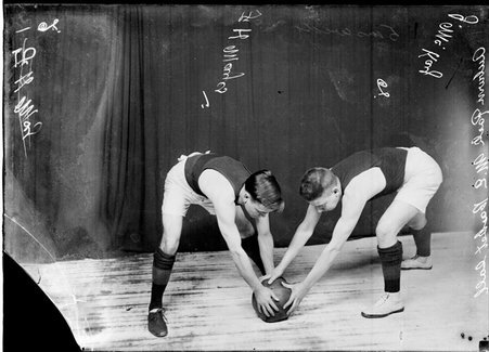 Auburn Park Methodist Episcopal Church basketball players F. H. Mayes and J. McKay posing, struggling for possession of the ball - Chicago Daily News, Inc.
