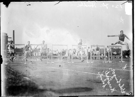 Harvard High School athlete Schobinger clearing a hurdle and leading the one-hundred twenty yard hurdles race - Chicago Daily News, Inc.