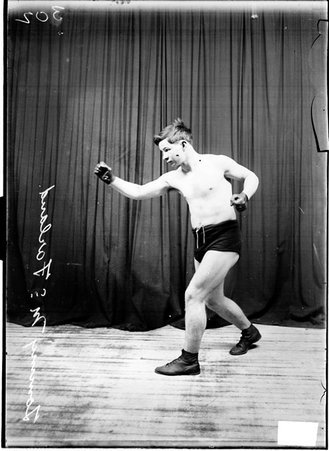 Boxer Tommy McFarland standing in an ordinary boxing stance facing the left side of the image - Chicago Daily News, Inc.