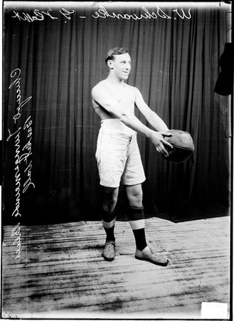 Chicago Turngemeinde Blues basketball player W. Schwanke holding a ball standing in front of a dark colored background - Chicago Daily News, Inc.