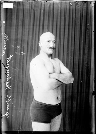Wrestler, Yussiff Mahmout standing with his arms crossed on his chest - Chicago Daily News, Inc.