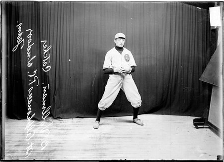 St. Alphonsus Presbyterian Church indoor baseball player B. Vollman holding a ball standing in front of a dark colored background - Chicago Daily News, Inc.