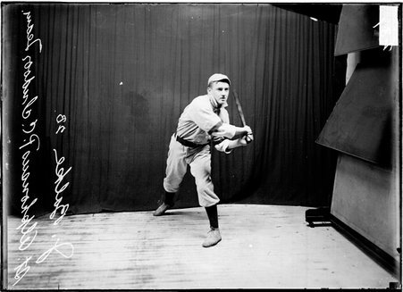 St. Alphonsus Presbyterian Church indoor baseball player J. Balke holding a bat standing in front of a dark colored background - Chicago Daily News, Inc.
