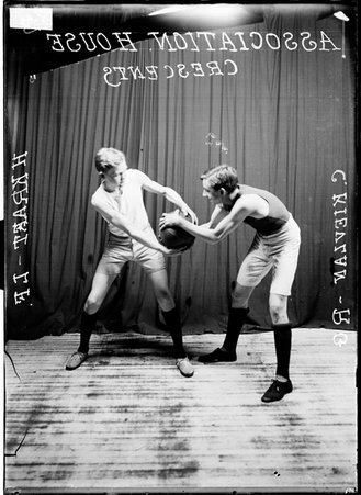 Association House Crescents basketball players C. Kievlan and H. Kraft posing in front of a dark colored background - Chicago Daily News, Inc.