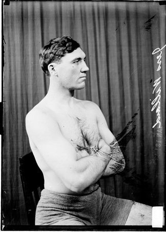 Pugilist, Jess Willard, sitting in profile in front of a dark backdrop - Chicago Daily News, Inc.
