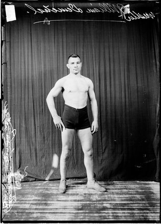Wrestler, William Demetral standing in front of a dark backdrop - Chicago Daily News, Inc.