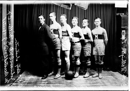 Basketball team, standing in front of a dark colored background - Chicago Daily News, Inc.
