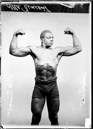 Wrestler, Illa Vincent flexing his biceps - Chicago Daily News, Inc.