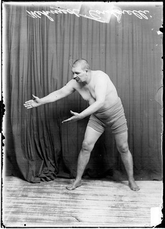 Wrestler, Mehmed Cordarelli in a wrestling stance with arms outstretched - Chicago Daily News, Inc.