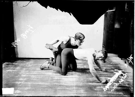 Wrestlers, George Bretz and Mike Sbarbaro posing in a wrestling hold in front of a light-colored backdrop - Chicago Daily News, Inc.