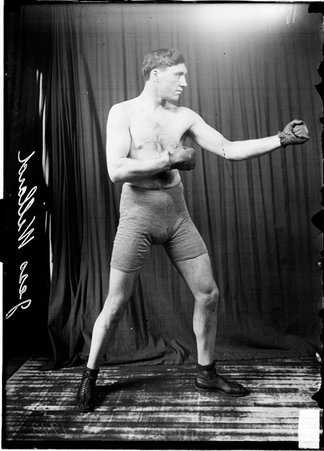 Pugilist, Jess Willard, facing image left, standing in profile in a boxing stance - Chicago Daily News, Inc.