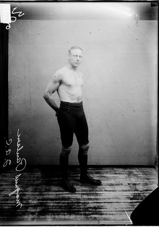 Wrestler, Magnus Paulsen, I. A. C., standing with his arms behind his back, right shoulder forward - Chicago Daily News, Inc.