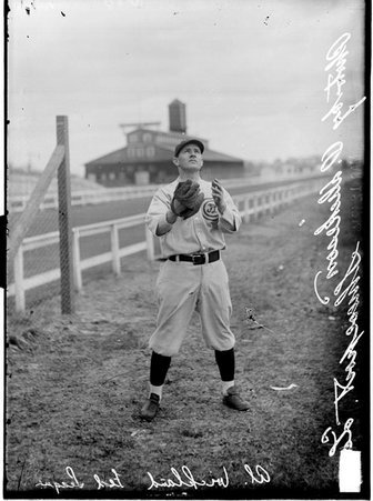 Baseball player, Al Wickland, Chicago Whales, posing in catching stance by a racetrack fence - Chicago Daily News, Inc.
