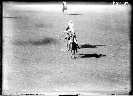Polo, East-West match, two players, with their mallets raised, riding toward the camera - Chicago Daily News, Inc.