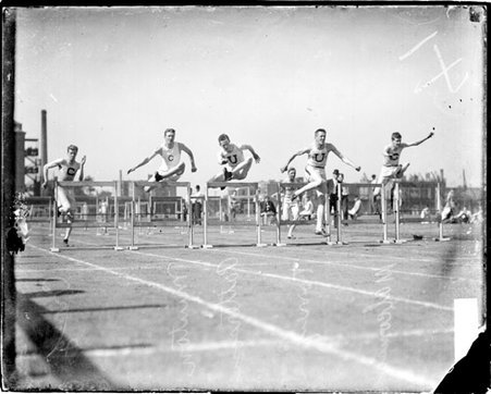 Athletes Minton, Torrey, R. Craig, Patterson, and Malcomson jumping over hurdles during a race on an athletic track - Chicago Daily News, Inc.