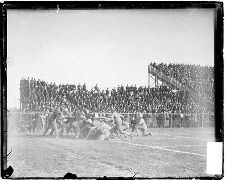 Football players lying and standing in a pile after a tackle during game between the University of Chicago and Northwestern University - Chicago Daily News, Inc.
