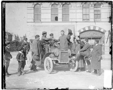 Automobile drivers Percy F. McGargle, D. F. Bassett sitting in an automobile parked in front of a building - Chicago Daily News, Inc.