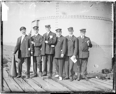 Sailors Balcome, Shaw, Osborne, Griffiths, and Finney standing on a dock - Chicago Daily News, Inc.