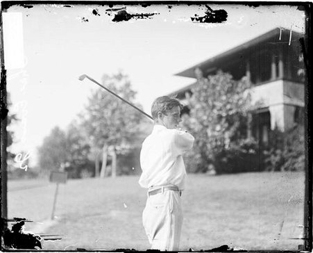 Golfer, Chick Evans golfer Chick Evans holding a follow-through position, standing in profile on the grounds of an unidentified golf club - Chicago Daily News, Inc.