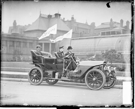 Three men sitting in a parked Chicago Daily News automobile in front of a building - Chicago Daily News, Inc.