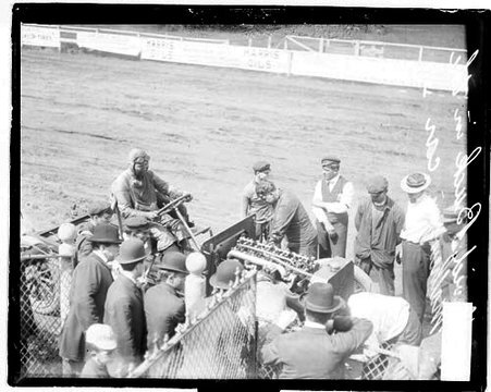 David Buck sitting in the driver's seat of the Mathewson automobile on unidentified racetrack - Chicago Daily News, Inc.