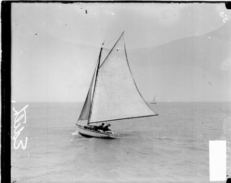 Yacht Edith sailing in a body of waterviewed at an angle, crew members are visible on the deck of the boat - Chicago Daily News, Inc.