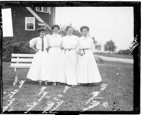 Golfers Mrs C L Dering, Miss Alva Sander, Miss Myra Helmer, and Miss M Edwards standing in front of a bench at a golf club - Chicago Daily News, Inc.
