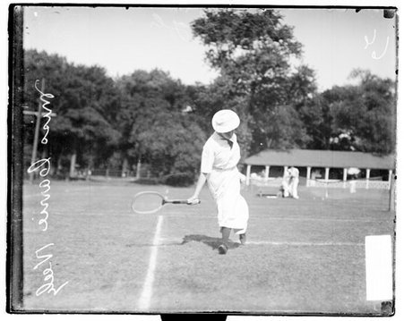Tennis player Carrie Neely holding a tennis racket and moving to her left on a tennis court - Chicago Daily News, Inc.