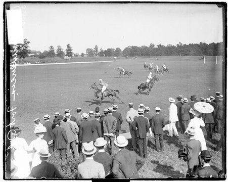 Two polo players riding horses in opposite directions during a polo game at Onwentsia Club - Chicago Daily News, Inc.