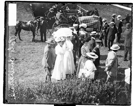 Two unidentified women standing beneath an umbrella on the sidelines of a polo field at Onwentsia Club - Chicago Daily News, Inc.