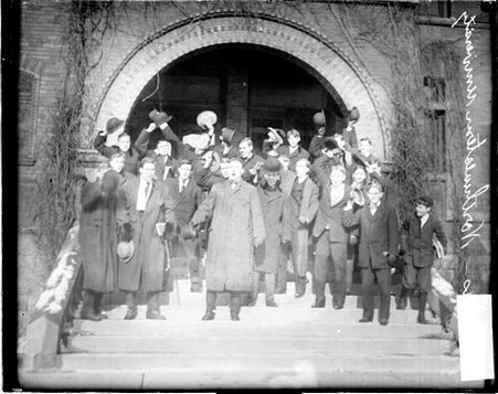 Northwestern University football fans, cheering, standing on the stairs in front of a building - Chicago Daily News, Inc.