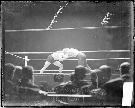 Wrestlers George Hackenschmidt and Frank Gotch standing and locking up in a wrestling maneuver in a wrestling ring - Chicago Daily News, Inc.