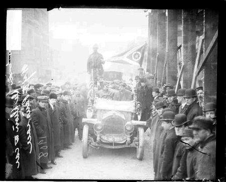 Unidentified men sitting in a De Dion automobile on a snow-covered street during a New York-Paris race - Chicago Daily News, Inc.