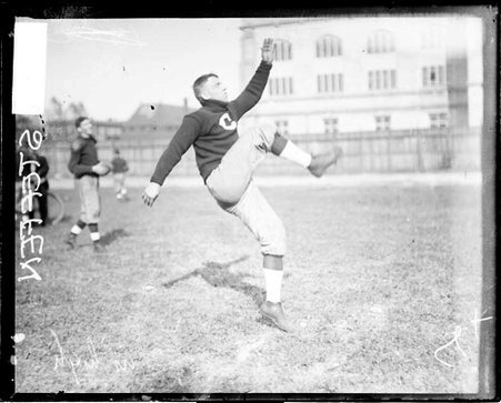 University of Chicago football player Walter Steffen following through after kicking a football, standing on one foot - Chicago Daily News, Inc.