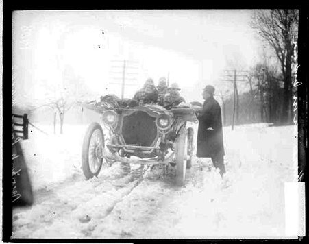 Men sitting in a Thomas automobile on a snow-covered road - Chicago Daily News, Inc.