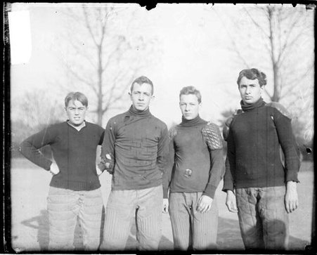 Hyde Park High School football players D. Green, Kronn, Irwin, and Potter standing outdoors - Chicago Daily News, Inc.