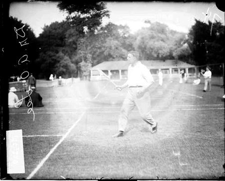 Tennis player Dr. A. O. Lee holding a tennis racket, standing on a tennis court - Chicago Daily News, Inc.