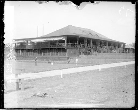 Clubhouse at the Skokie Golf Club viewed from across a path passing in front of the building - Chicago Daily News, Inc.