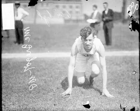 Wendell Phillips High School athlete Henry McGregor crouching in a ready position on the field at Marshall Field - Chicago Daily News, Inc.