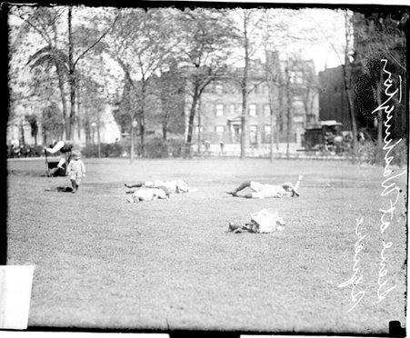 Four children lying on a grass lawn in Washington Square - Chicago Daily News, Inc.