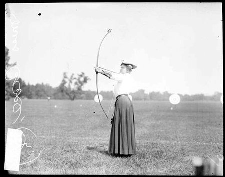 Archer Miss Harriet Chase holding a bow and arrow and pulling back the bow string - Chicago Daily News, Inc.