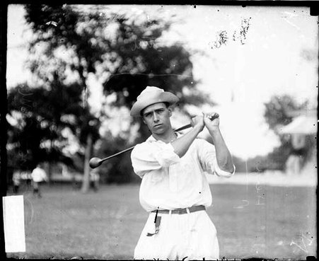 Unidentified golfer holding a golf club over his shoulder, standing in a follow-through position - Chicago Daily News, Inc.