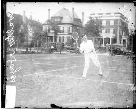 Tennis player Walter Hayes holding a tennis racket with his right hand and drawing back his right arm - Chicago Daily News, Inc.