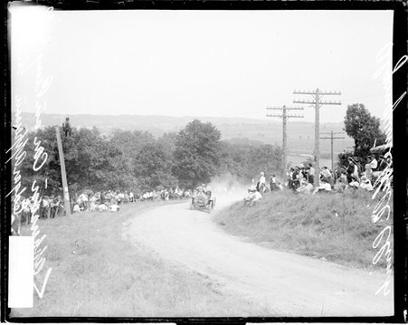 Automobile driver Edgar Apperson driving an Apperson automobile up a dirt road, during the Algonquin Hill Climbing Contest - Chicago Daily News, Inc.