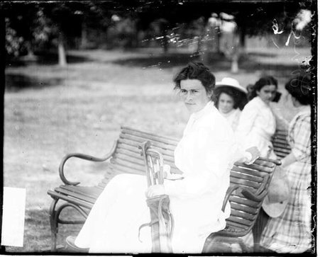 Golfer Miss W. M. Lovell sitting on a bench on the grounds of an unidentified golf course - Chicago Daily News, Inc.