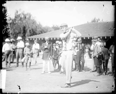 Golfer W. Lee holding a golf club over his shoulder, standing in a follow-through position on a tee - Chicago Daily News, Inc.