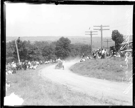 Unidentified automobile driver driving a Maxwell automobile up a dirt road on a hill - Chicago Daily News, Inc.