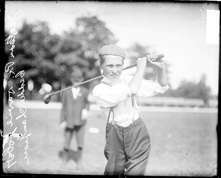 Golfer and caddie Devine Kober, winner of a caddie championship, holding a golf club over his shoulder - Chicago Daily News, Inc.