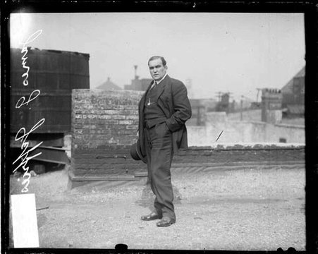 Boxer, James J. Jeffries facing to the left of the camera and looking at the camera, standing on the roof of a building - Chicago Daily News, Inc.